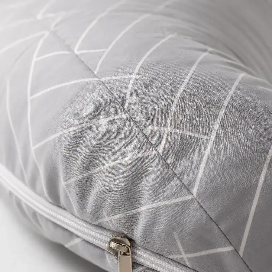 Close-up of the pillow’s seam and zip, gray fabric with fine white herringbone