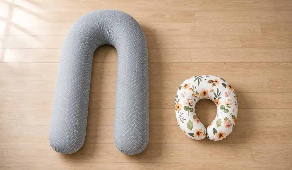 The two pillows side by side on a wooden floor: the large U on the left, the compact nursing pillow on the right